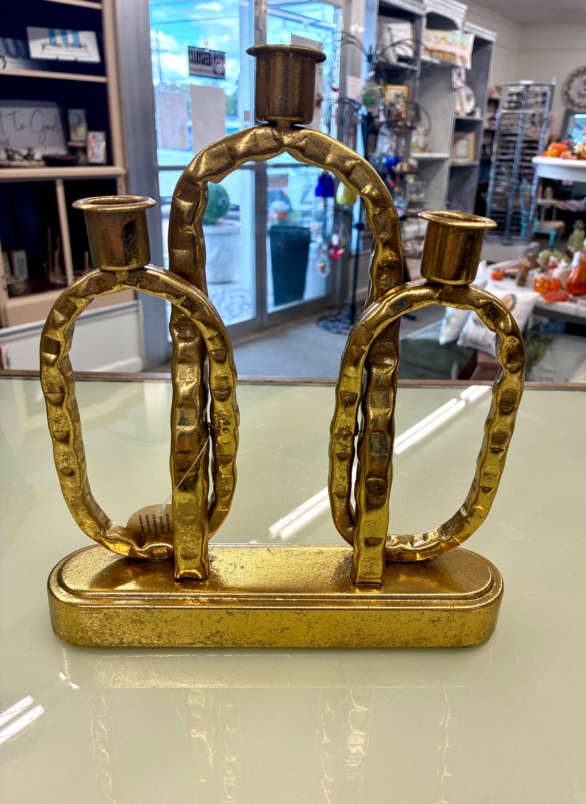 Gold-toned metal interlocking-link decorative candle holder with a rectangular base.