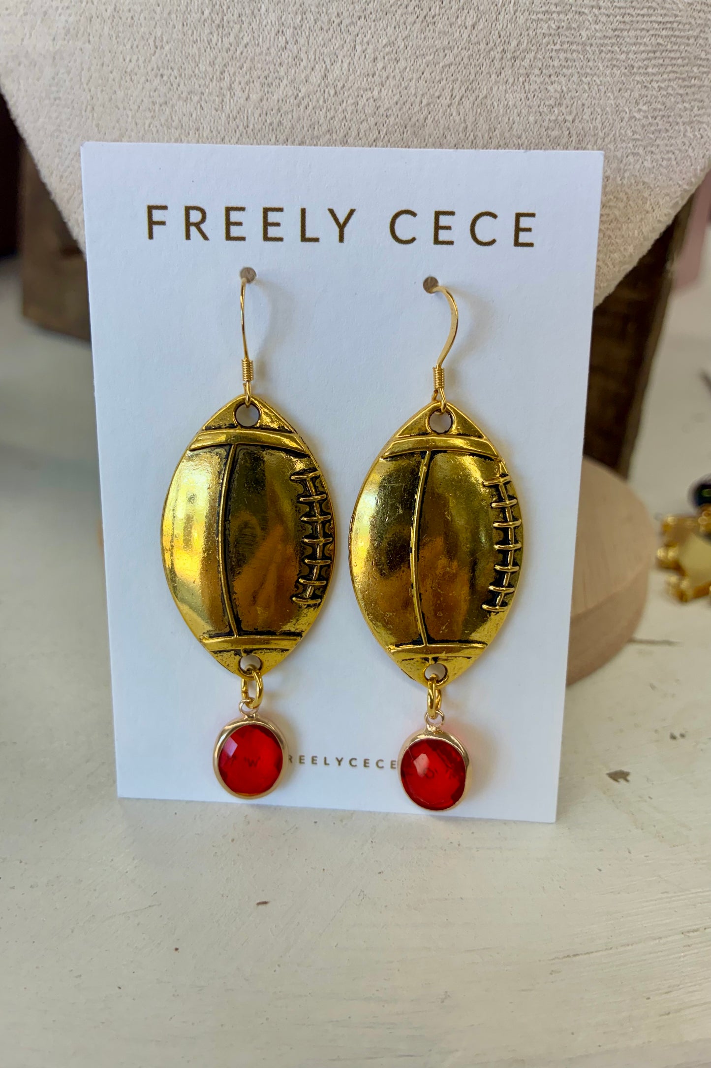 Gold Iridescent Football Earrings with Red Stone
