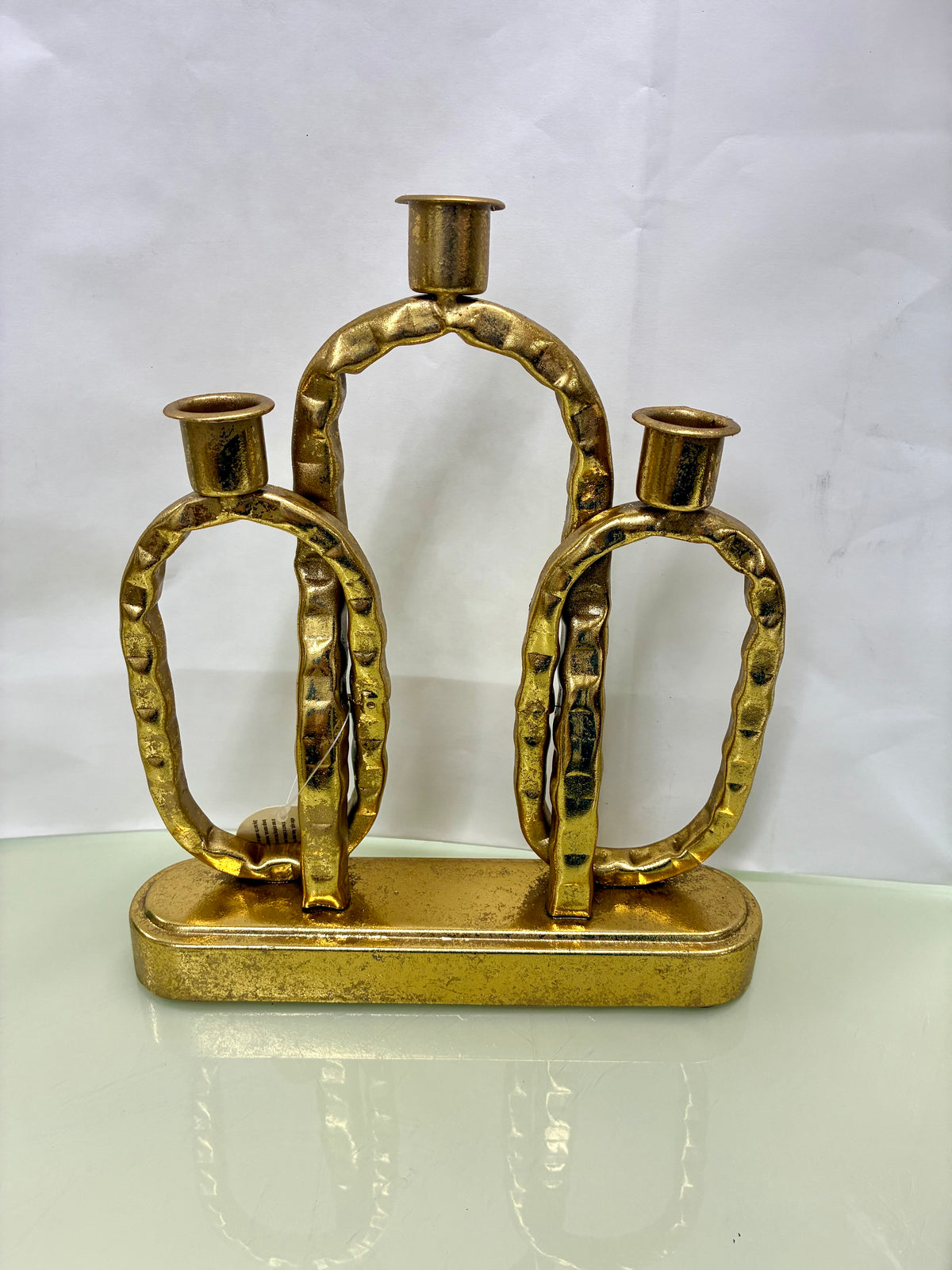 Gold-toned metal interlocking-link decorative candle holder with a rectangular base.