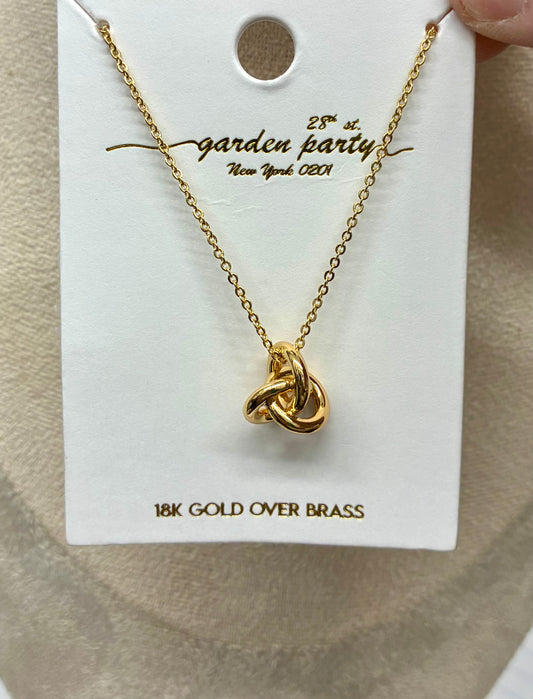 gold-tone interlocking knot pendant necklace from featuring a polished sculptural knot design on a delicate chain.