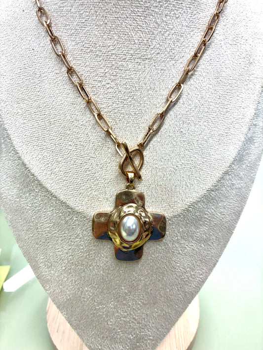 Gold-tone hammered cross necklace and matching earrings sold separately set featuring a central pearl accent and a toggle clasp.