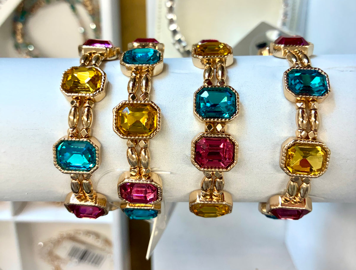 Gold tone multi-color emerald-cut crystal stretch bracelet featuring alternating vibrant teal, yellow, and hot pink faceted stones.