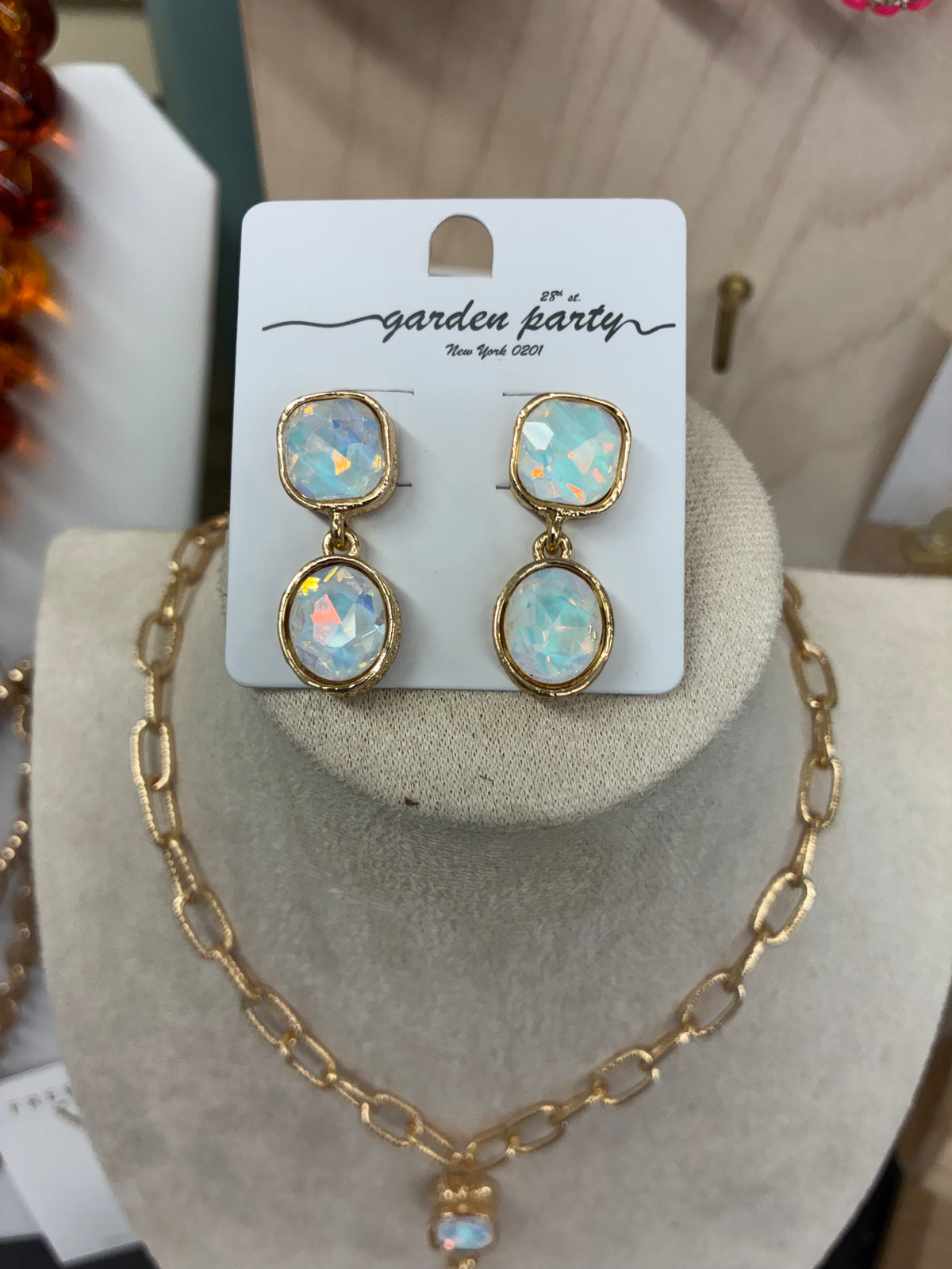 Gold-tone chunky link lariat necklace featuring iridescent opalescent stone drops with matching earrings.  Sold separately.