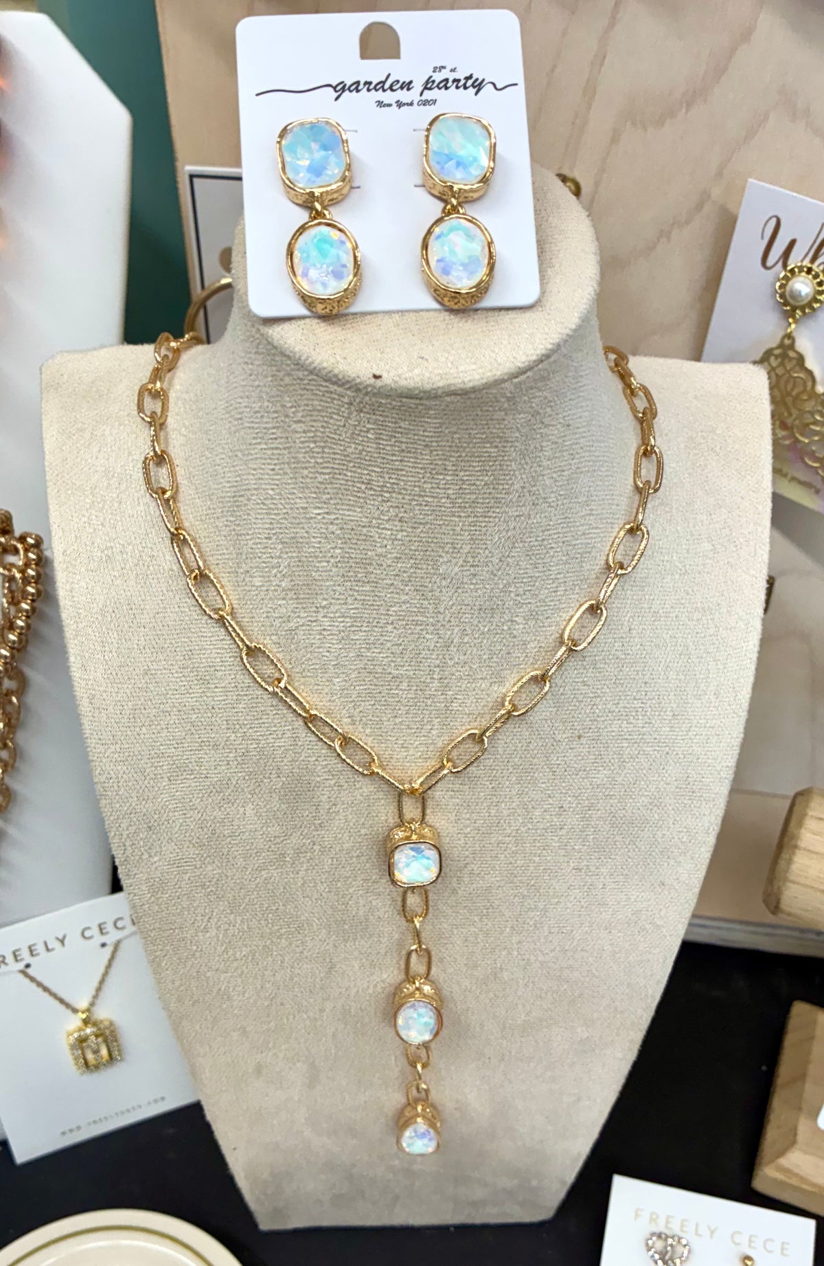 Gold-tone chunky link lariat necklace featuring iridescent opalescent stone drops with matching earrings.  Sold separately.
