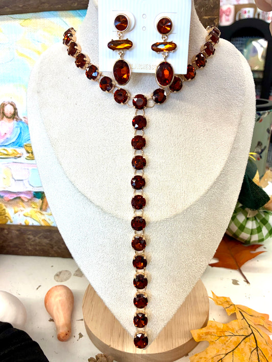 Rust & Gold Round Y-Drop Rhinestone Necklace / Gold toned multi-stone dangle earrings featuring faceted amber-brown stones in round, horizontal bar, and oval shapes.