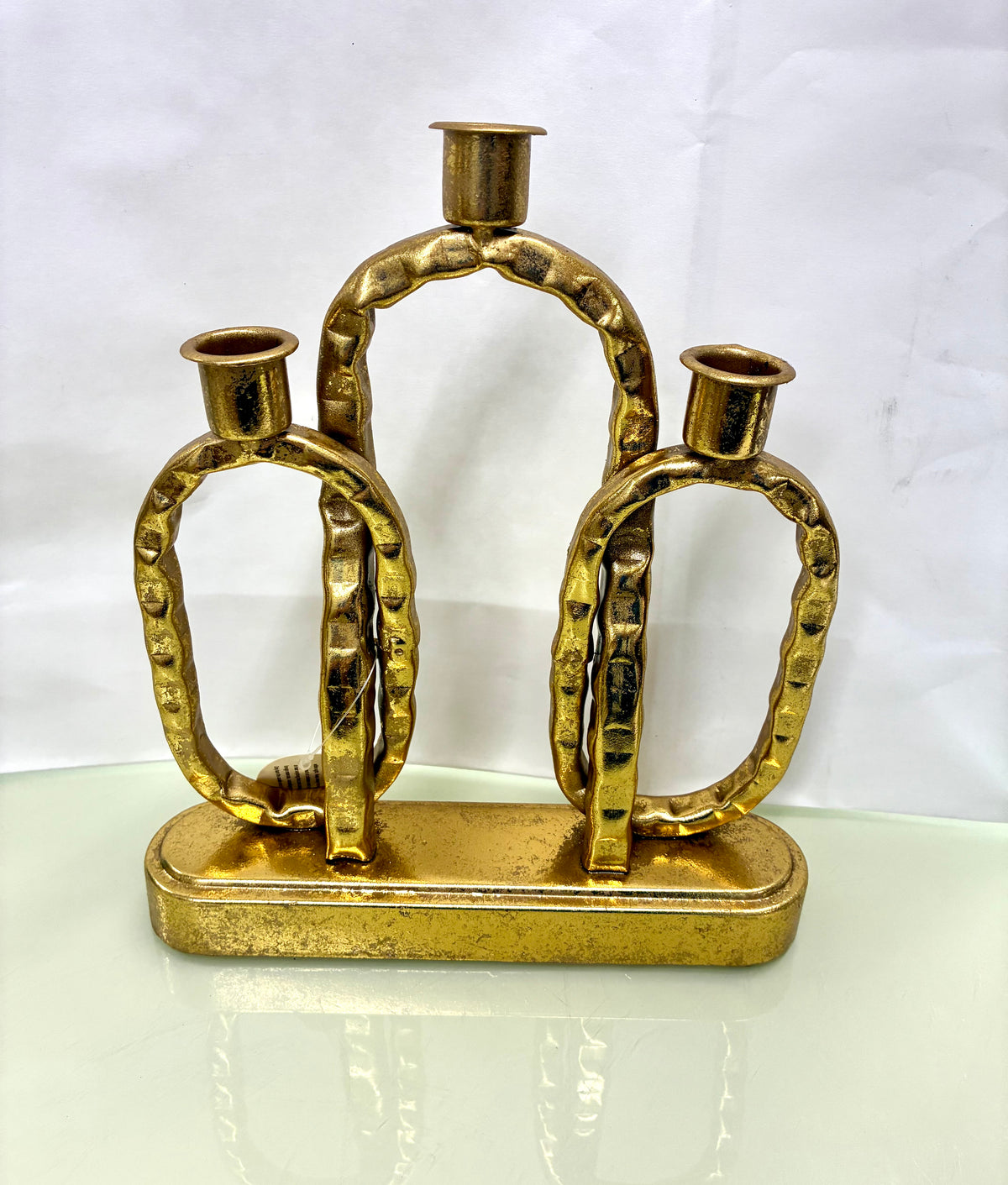 Gold-toned metal interlocking-link decorative candle holder with a rectangular base.