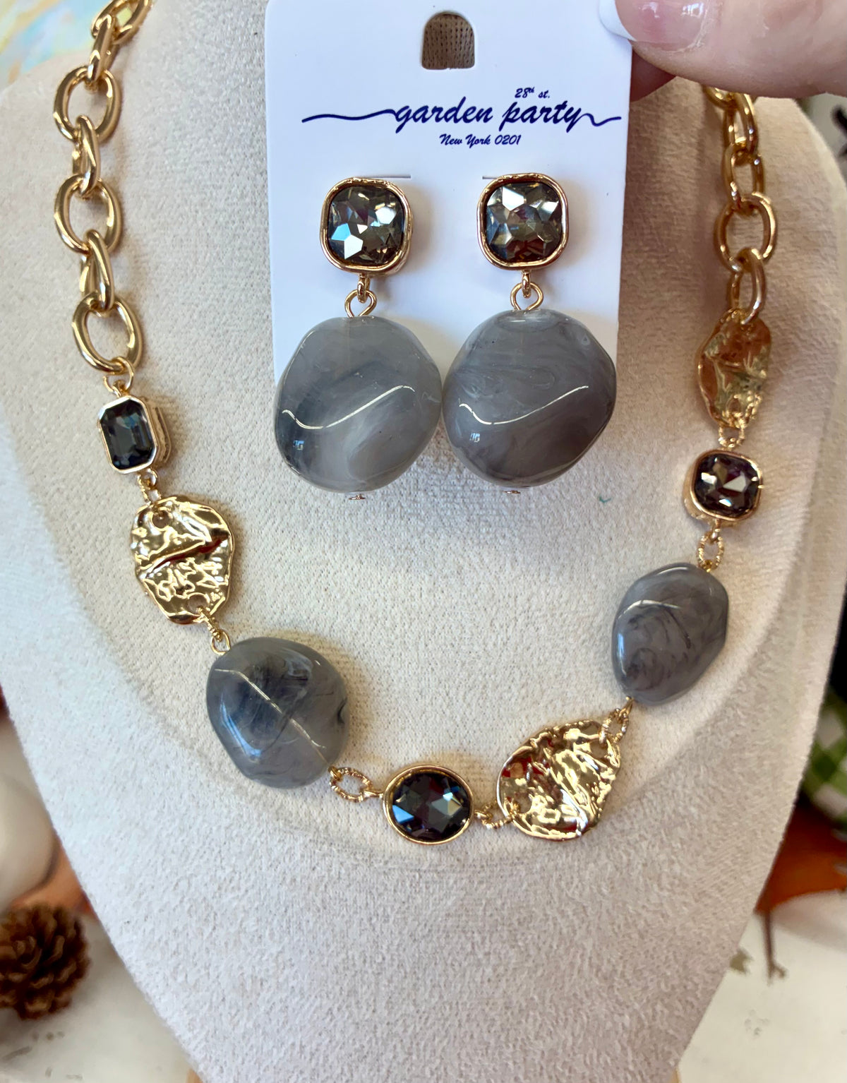 Gold chunky link necklace featuring smooth grey stone beads and textured golden accent pieces