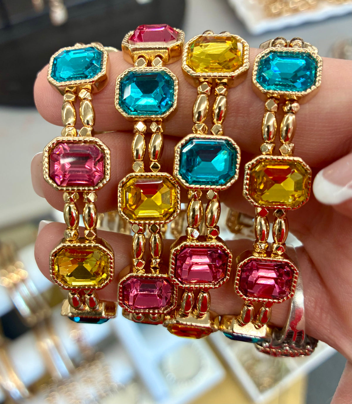 Gold tone multi-color emerald-cut crystal stretch bracelet featuring alternating vibrant teal, yellow, and hot pink faceted stones.