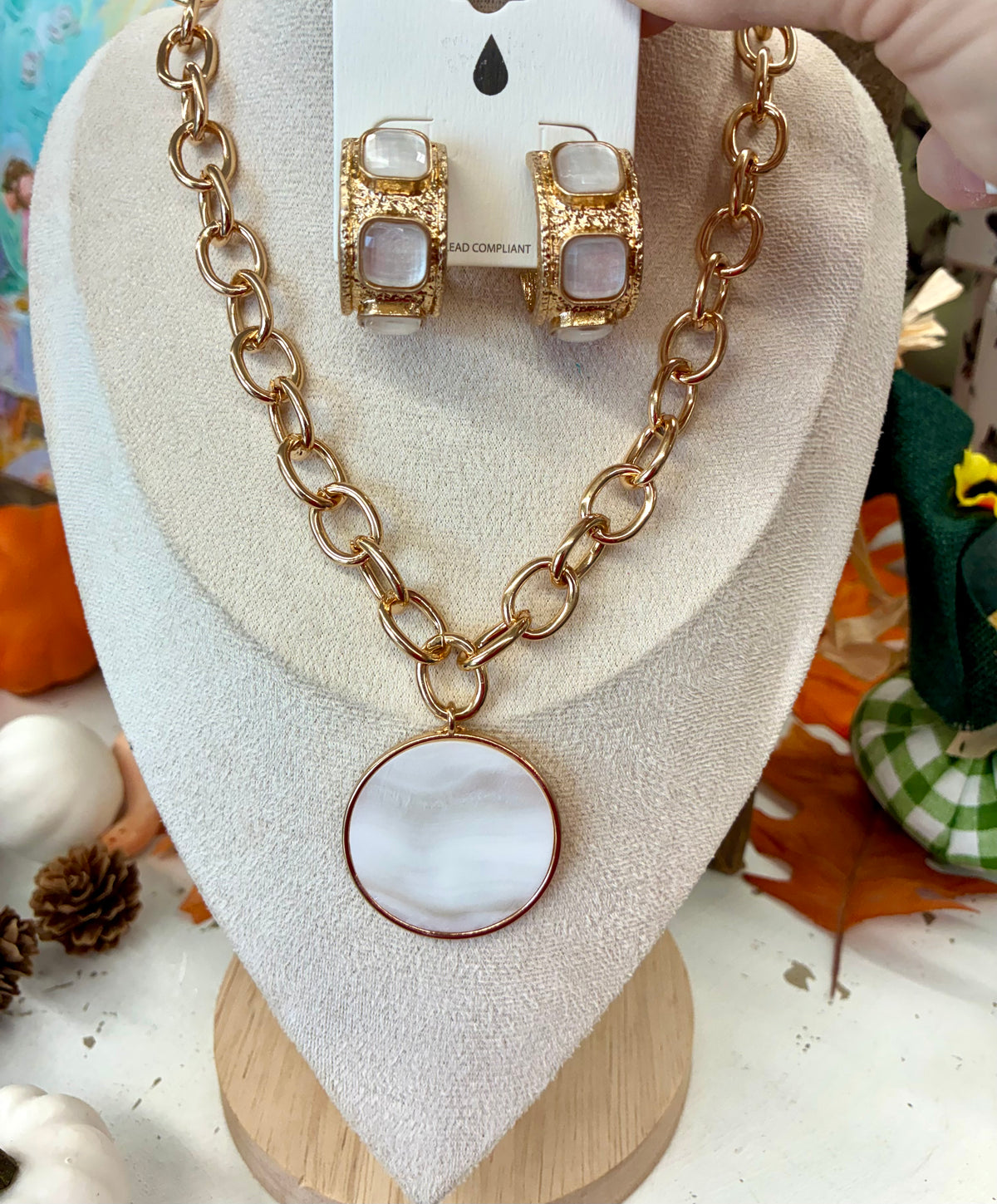 Chunky gold-tone link chain necklace featuring a large, round white pendant